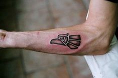 a man's arm with a tattoo on it and a knife in the middle