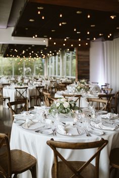 the tables are set with white linens and place settings for an elegant wedding reception