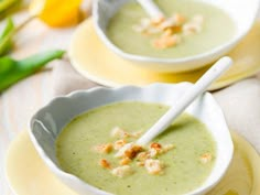 two bowls filled with soup on top of yellow plates