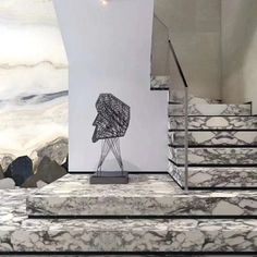 an artistic piece of art on display in front of a staircase with marble steps leading up to it