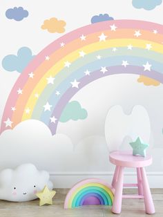 a child's room with rainbow wall decals and cloud decorations on the walls