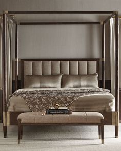 a bedroom with a canopy bed and footstool on the floor next to it