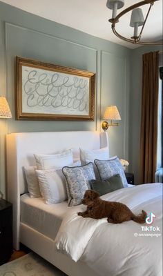 a dog laying on top of a white bed in a bedroom next to a window