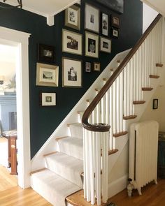 a staircase with pictures on the wall above it and a radiator in front