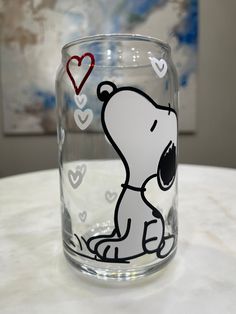 a glass with a drawing of a dog on the side and hearts drawn on it