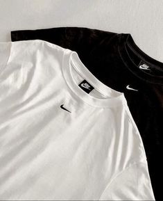 two black and white nike shirts sitting next to each other