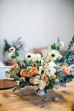 an arrangement of flowers in a vase on a table