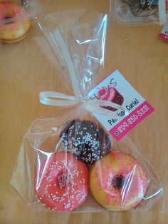 four donuts wrapped in cellophane with sprinkles and a price tag