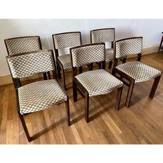 six chairs are lined up against the wall in a room with hardwood floors and hard wood flooring