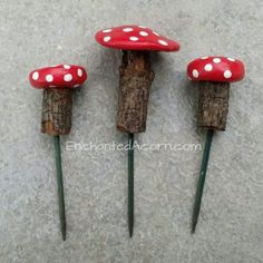 three red mushrooms with white dots on them sitting on top of each other in front of a wall