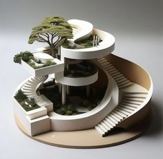 a model of a house with stairs and trees on the top floor, surrounded by greenery