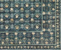 an antique rug with blue and beige colors