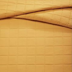 an image of a bed with yellow sheets and pillowcases on top of it