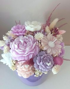 a purple vase filled with lots of different colored flowers