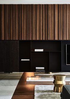 a modern living room with wood paneling on the wall