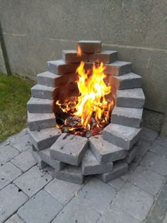 a fire pit made out of cinder blocks on the ground with flames coming from it