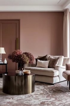 a living room with pink walls and furniture