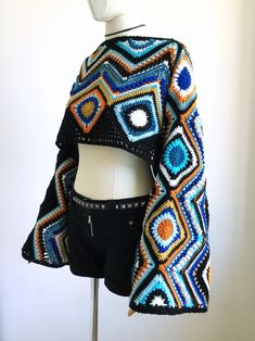 a crocheted jacket is displayed on a mannequin's head and torso