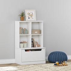 a white bookcase sitting on top of a floor next to a blue bean bag