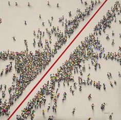 a large group of people standing next to each other in the shape of an arrow