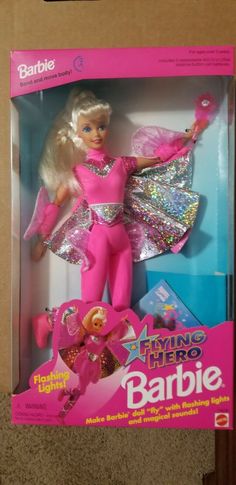 the barbie doll is in its box and it's pink with silver sequins