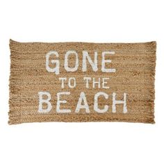 a door mat with the words gone to the beach written in white ink on it