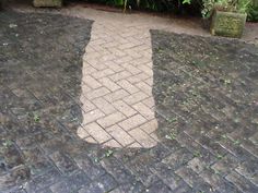 an arrow shaped brick path in the middle of a garden