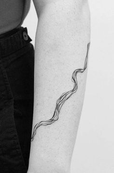 a black and white photo of a woman's arm with a wave tattoo on it