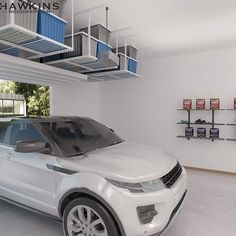 a white car is parked in a garage with shelves on the wall and an open door