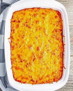 a cheesy casserole in a white dish on a checkered cloth