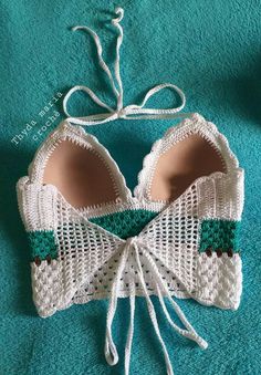 a crocheted bra with green and white trim