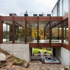 an open air hot tub in the middle of a patio area with glass walls and windows