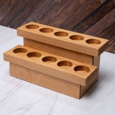 two wooden boxes sitting on top of a white table next to each other with holes in them