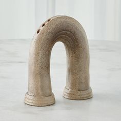 a stone sculpture that looks like it has a hole in the middle and is shaped to look like an arch