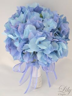 a bouquet of blue flowers on a white background with purple ribbon around the top and bottom