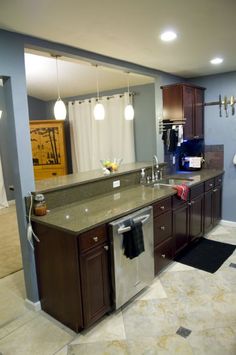 a large kitchen with an island and stainless steel dishwasher in it's center