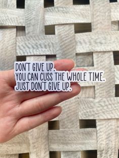 someone holding up a sticker that says, don't give up you can cuss the whole time just don't give up