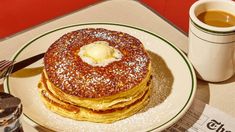 a stack of pancakes sitting on top of a white plate next to a cup of coffee