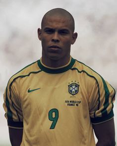 a soccer player is posing for the camera with his hands on his hips and looking at the camera