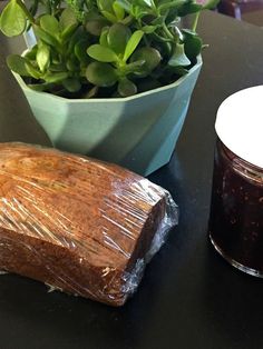 a table topped with a bowl of green plants and a loaf of bread