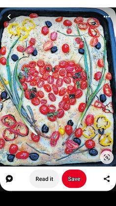 a heart shaped pizza with tomatoes and olives on it