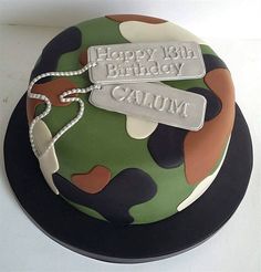 a camouflage birthday cake with two tags on the top, and an inscription happy 10th birthday gaum