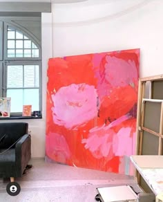 an abstract painting is displayed in front of a window