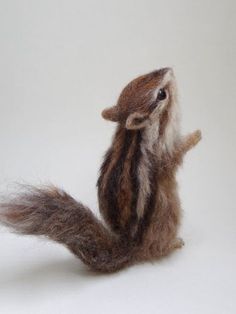 a needle - felt squirrel sitting on its hind legs and looking up at the sky