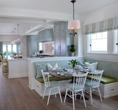 a kitchen and dining room area in a house with wood floors, white walls, and blue cabinets