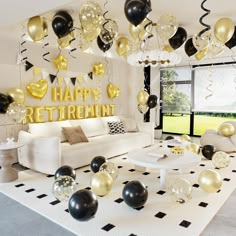 a living room filled with balloons and black and gold decorations