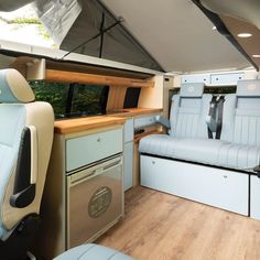 the inside of a camper with blue leather seats and wood flooring is shown