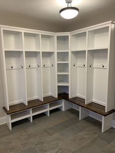 an empty room with white cabinets and benches