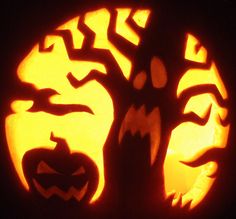 a carved pumpkin with an image of a tree in the center and two jack - o'- lantern faces on it