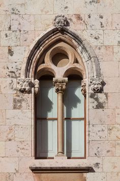 an old building with two arched windows on each side and stone work around the window sill